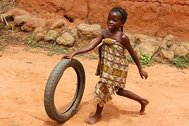 Child playing with a tyre.