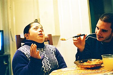 Man feeding woman with Down's Syndrome