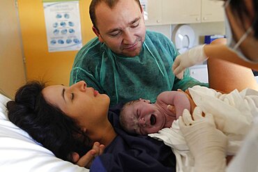 Woman and husband with newborn in hospital