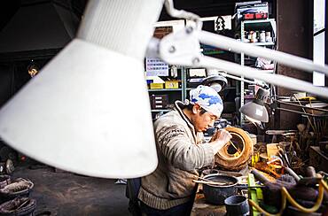 Takahiro Koizumi is making the outer mold of a new design of a iron teapot or tetsubin, nanbu tekki, Workshop of Koizumi family,craftsmen since 1659, Morioka, Iwate Prefecture, Japan