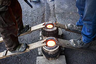 Takahiro Koizumi and his assistant Kohei ishimori are waiting that solidify the molten iron inside the molds, to make a iron teapot or tetsubin, nanbu tekki,Workshop of Koizumi family,craftsmen since 1659, Morioka, Iwate Prefecture, Japan