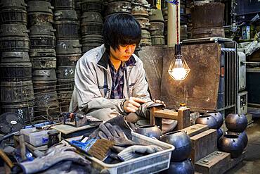 craftsman is putting the finishing touches at iron teapot or tetsubin, nanbu tekki, in Workshop of Morihisha Suzuki,craftsmen since 1625, Morioka, Iwate Prefecture, Japan