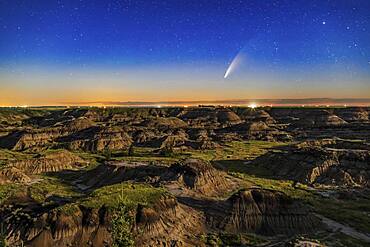 This is Comet NEOWISE (C/2020 F3) over the Horseshoe Canyon formation near Drumheller, Alberta on the night iof July 10-11, 2020, taken about 2 a.m. MDT with the comet just past lower culmination with it circumpolar at this time. Warm light from the rising waning gibbous Moon provides the illumination. The comet's faint blue ion tail is just barely visible even in the moonlit sky and low altitude.  The glow of summer perpetual twilight at latitude 51.5�8 N still colours the northern horizon despite this being close to the middle of the night.