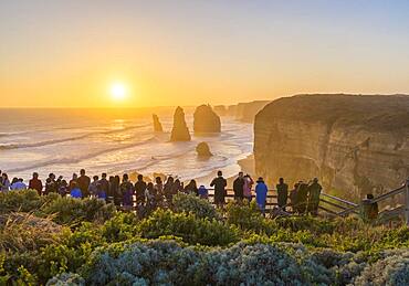 Tourists watching and photographing the sunset at the first and main Twelve Apostles viewpoint, on the Great Ocean Road, Australia.