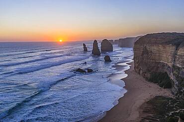 The setting Sun at the Twelve Apostles sea stacks and cliffs on the Great Ocean Road, on April 12, 2017.