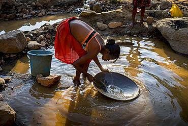 Girl miss school to pan for gold in the mountains near Ankavandra, Madagascar