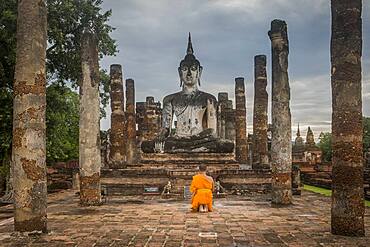 Monk praying, in Wat Mahathat, Sukhothai Historical Park, Sukhothai, Thailand