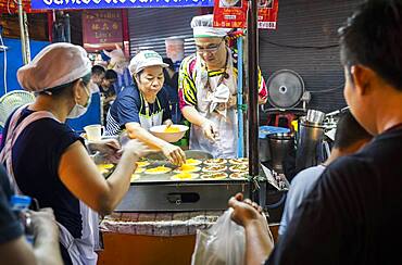 Cooking khanom buang sweet coconut crepes, Street food night market, at Yaowarat road, Chinatown, Bangkok, Thailand