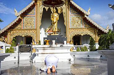 woman praying, in Wat Phra Singh temple, Chiang Mai, Thailand