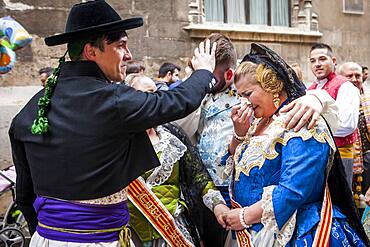 After seeing the Virgin, woman and men in Fallero Costumes crying during Flower offering parade, tribute to `Virgen de los desamparados��, Fallas festival, Plaza de la Virgen square,Valencia