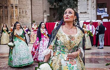 woman looks with emotion the Virgin during flower offering parade,People with Floral tributes to `Virgen de los desamparados��, Fallas festival, Plaza de la Virgen square,Valencia