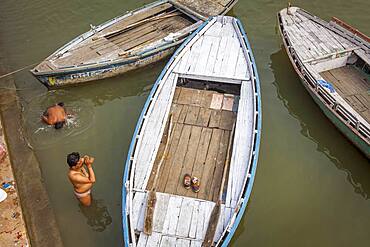 Men praying and bathing, in the ghats of Ganges river, Varanasi, Uttar Pradesh, India.