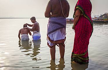 Pilgrims praying and bathing, in the ghats of Ganges river, Varanasi, Uttar Pradesh, India.