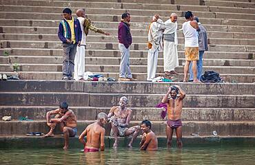 Pilgrims praying and bathing, in the ghats of Ganges river, Varanasi, Uttar Pradesh, India.