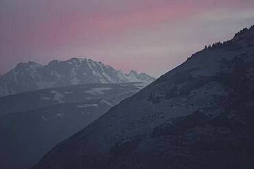 The sky is glowing softly as the sun sets behind the mountains of the Kluane National Park. Yukon Territory, Canada