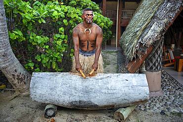 Tradtional Fijian Warrior playing the drum in Malolo Island Resort and Likuliku Resort, Mamanucas island group Fiji