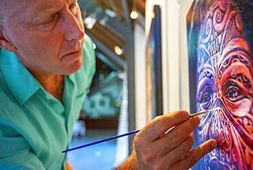 The portrait painter Stephen Bennett doing a polynesian painting in Meridien Hotel on the island of Tahiti, French Polynesia, Tahiti Nui, Society Islands, French Polynesia, South Pacific.