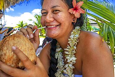 Woman drinking coconut milk in Fakarava,  Tuamotus Archipelago French Polynesia, Tuamotu Islands, South Pacific.