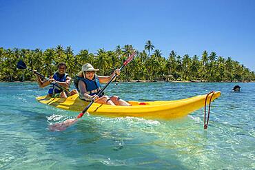 Kayaking in Taha'a island beach, French Polynesia. Motu Mahana palm trees at the beach, Taha'a, Society Islands, French Polynesia, South Pacific.