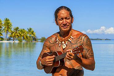 Island of Taha'a, French Polynesia. A local boy plays the ukulele to woo your girl at the Motu Mahana, Taha'a, Society Islands, French Polynesia, South Pacific.