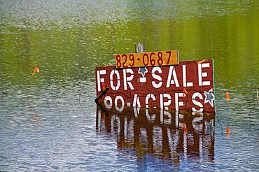 Flooded field property for sale sign.