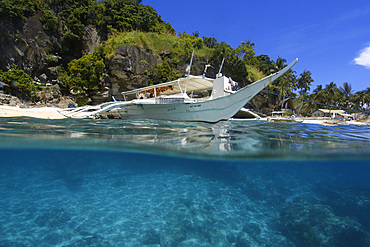 Over under of banca and sandy seafloor, Apo island Marine Reserve, Philippines.