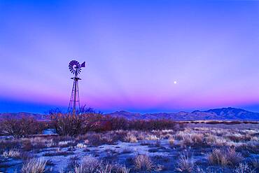 Sunset twilight colours and the waxing gibbous Moon over the Chiricahua Mountains in southeast Arizona, south of Willcox. Taken December 15, 2013 on Highway 186. Taken with the 24mm lens and Canon 5D MkII. Some dark crepuscular rays are visible converging to the anti-solar point.