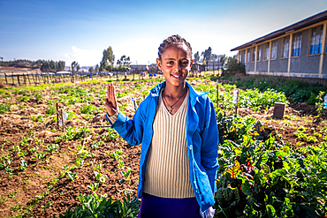 A young Ethiopian farmer posing in a field for a photograph, Debre Berhan, Ethiopia