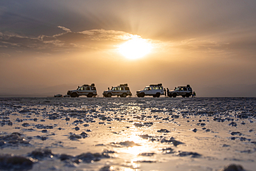 Tourist on the salt flats next to Land Cruisers in the Danakil Depression, Ethiopia