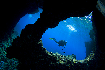 A diver swims past Boo Windows on Boo Island, Raja Ampat, West Papua, Indonesia, Pacific Ocean