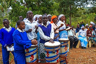 Playing drums in a funeral for the death of a person due to Coronavirus and AIDS in a small village near Kitui city in the Kamba country in Kenya, Africa.