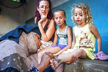 Swahili Woman paint with Henna And Indigo some european tourists in Lamu, Lamu Archipelago, Kenya