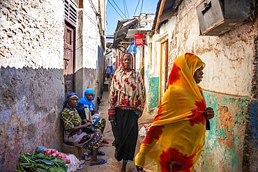 Swahili women with colorful veils in the strees of the city town of Lamu in Kenya