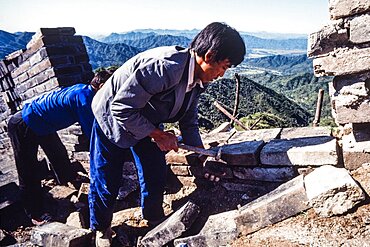 Two Chinese men working on the restoration of the Great Wall at Mutianyu, China.