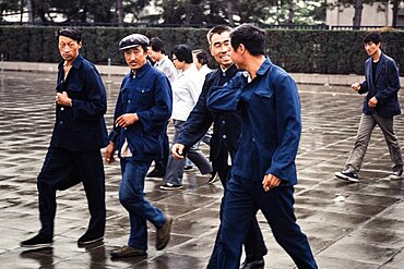 Chinese tourists crossing Tiananmen Square in the rain.