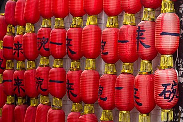 Rows of red Chinese lanterns symbolising good fortune for sale in a shop in Fenghuang, China.