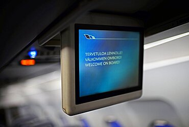 Screen in plane reads Welcome on Board in English and Finnish