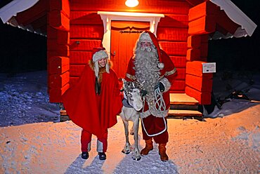 Santa Claus poses with Elf and Reindeer. Santa¥s Home in Kakslauttanen Arctic Resort. Lapland, Finland