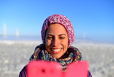 Young woman using mobile phone during Sampo Icebreaker cruise, an authentic Finnish icebreaker turned into touristic attraction in Kemi, Lapland