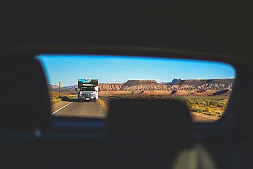 View of camper van on road from car back window, Montana, USA