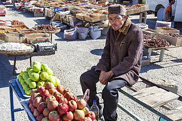 Man selling apples in an outdoor market, near Samarkand, Uzbekistan