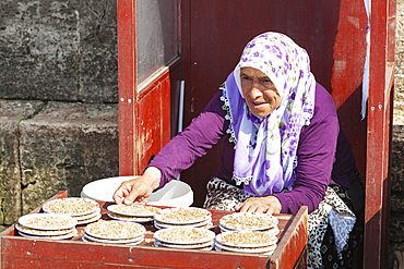 Woman selling food for pigeons at the New Mosque, Eminonu Yeni Camii, Eminonu, Istanbul, Turkey