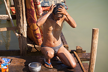 Man washing himself beside Inle Lake, Indein Village, near Taunggyi, Shan State, Myanmar, (Burma)