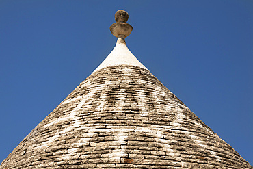 Conical dry stone roof of trulli house, with painted sun symbol, Alberobello, Bari province, Puglia region, Italy