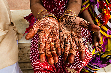 A woman showing her henna tattoed hands