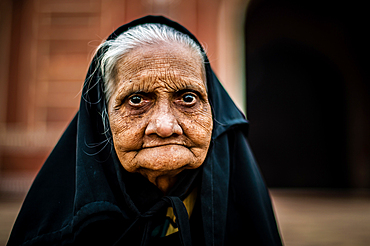 An old muslim woman visiting the mosque in the Taj Mahal