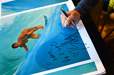 Pro surfer Sally Fitzgibbons signs posters