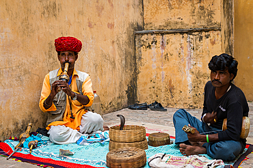 Man playing musical instruments and charming snakes