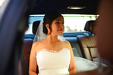 Latin bride in wedding car, nervous before the celebration