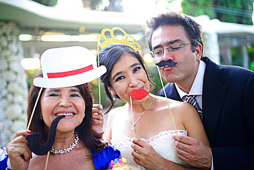 Just married couple playing with costumes and guests in wedding party